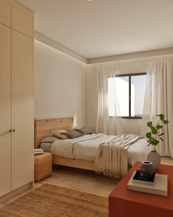 Dormitorio con luz natural y textiles cálidos en reforma integral de vivienda